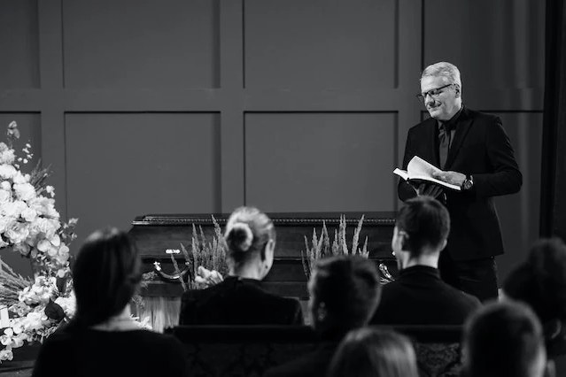 Cérémonie d'obsèques, un officiant lisant un texte devant l'assemblée